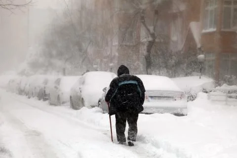 Old man trying to go to work on a snowy day Stock Photos