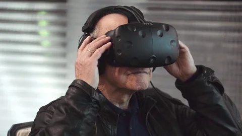 Old man trying VR mask in futuristic decor Stock-Footage 69771348