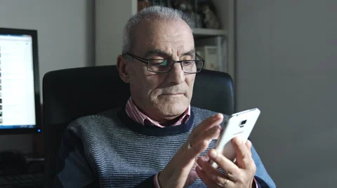 Old man typing on touch screen of a modern mobile phone: smartphone Stock Footage 47614103