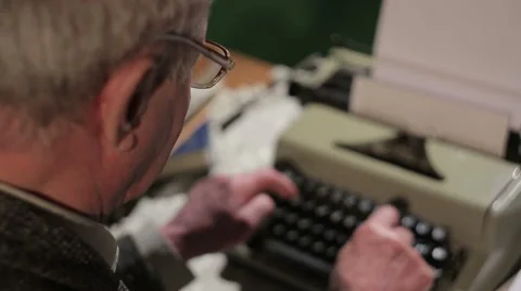 Old man is typing on a typewriter Stock Footage 53266815