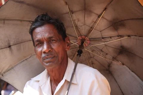 Old man under an umbrella Stock Photos