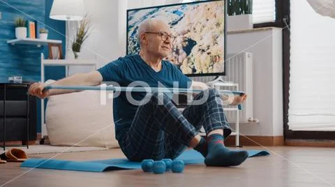 Elder adult sitting on yoga mat and pulling resistance band Stock Photo by  DC_Studio