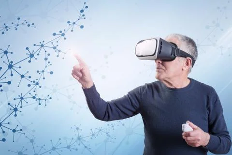 An old man using a virtual reality headset against an abstract background with Foto stock