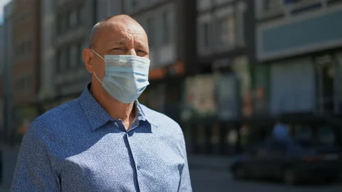 Old man walk down street despite Covid-19. Coronavirus epidemic. People in mask. Stock Footage 137531463