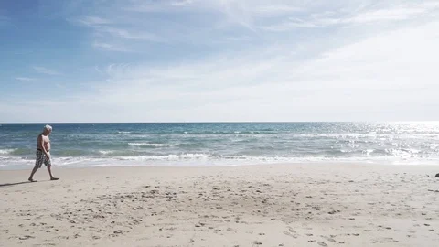 Old man walking on the beach Stock Footage 89693137
