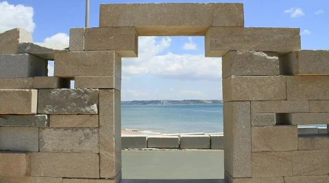Old Man Walking By The Beach Framed in a Stone Window 스톡 동영상 765516