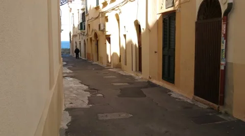 Old man walking in characteristic small street in Gallipoli, Italy Stock Footage 58845797