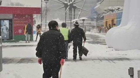 An old man is walking to clear the snow Stock Footage 85326296