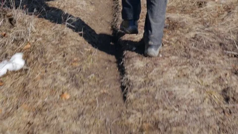 Old man walking on muddy soil Stock Footage 104402209