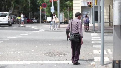 Old man with a walking stick and a medical face mask waits at the crosswalk. Stock Footage 133898560
