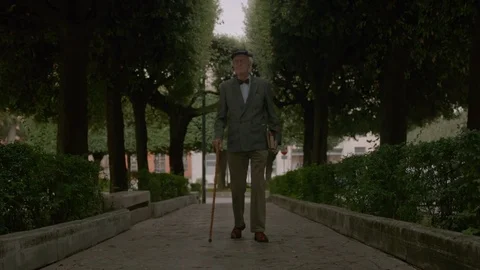 Old Man Walking In The Street Stockbeeldmateriaal 75174565