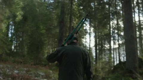 Old man walking through a forest with shears Stock Footage 314858037
