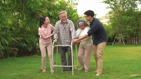The old man was walking with a walker in the backyard, with a family with a wife Stock Footage 136660500