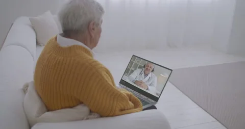 Old man is watching tv programme about health by laptop, professional doctor is Stock Footage 138208271