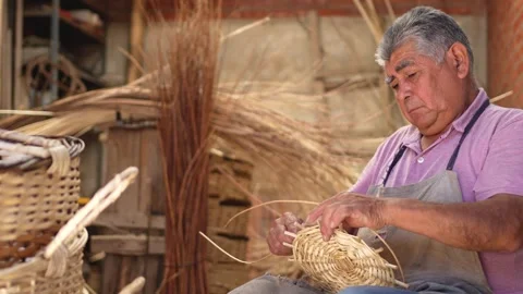 Old man weaving wicker basket at his workshop. Latin American Culture concept Stock Footage 285425541