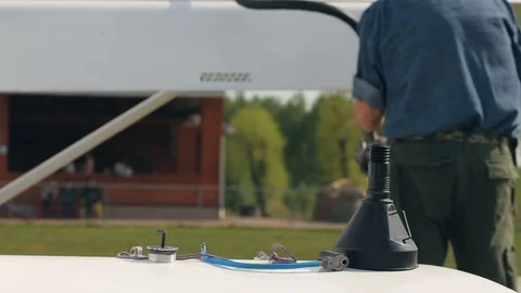 Old man worker refuels plane with fuel on field at airport and folds equipment. Stockbeeldmateriaal 119983395