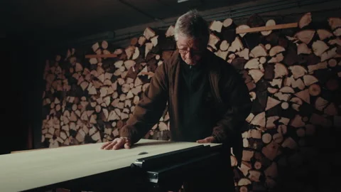 Old man working with a circular saw cutting a piece of wood in straight line Stock Footage 139756587