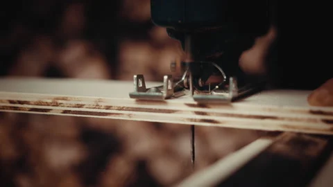 Old man working with a jigsaw cutting a piece of wood in a straight line Stock Footage 139755467