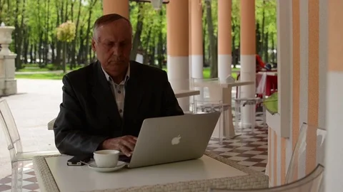 Old man working with the laptop in the cafe Stock Footage 72076917