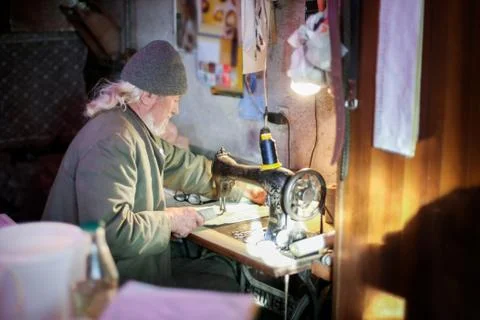 Old man working on sewing machine Stock Photos