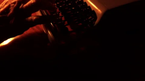 Old man working under the small table lamp and typing on typewriter machine Stock Footage 149523971