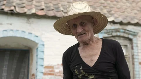 Old man with wrinkled face stands near shabby house wall Stock Footage 201303424