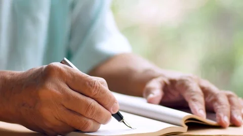 Old man write on blank notebook page with black ink pen Stock Footage 80903781