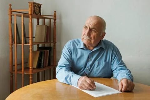 Old man writing notes or deciding to sign Stock Photos