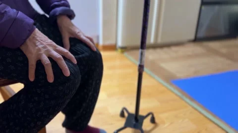 The old man's hand sitting with a cane beside him.. Video stock 232197383