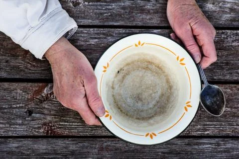 Old man's hands hold an empty old bowl Stock Photos