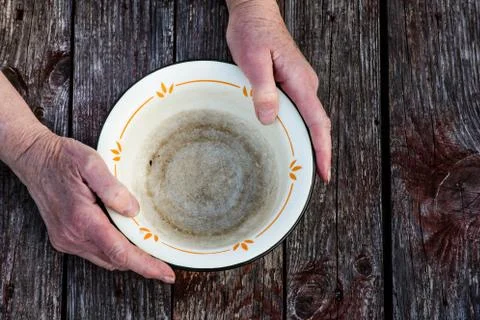 Old man's hands hold an empty old bowl Stock Photos