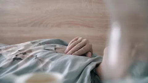 Old man's hands. An old, infirm grandfather is lying on a bed in a hospice. Old Stock Footage 254619581