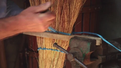 Old man’s hands tying together traditional straw broom Stock Footage 81657265