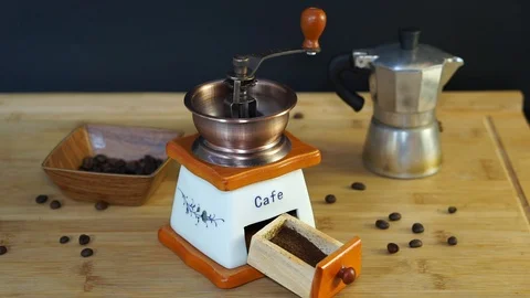 Old manual coffee grinder completing the process of grinding coffee beans Stock Footage 104719275