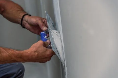 Old manual worker with wall plastering tools renovating house Stock Photos