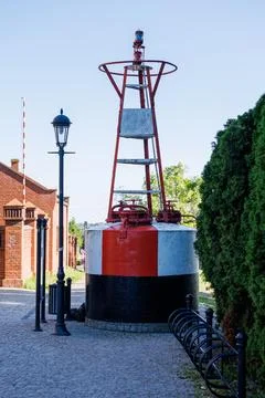 An old maritime navigation buoy installed on a paved street near a vintage .. Stock-Fotos