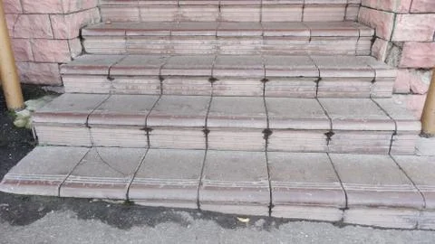 Old maroon stone steps covered with graphite with scratches Foto stock