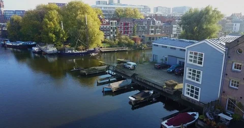 Old masted barge moored beside a gray clapboard boathouse Stock-Footage 71294704