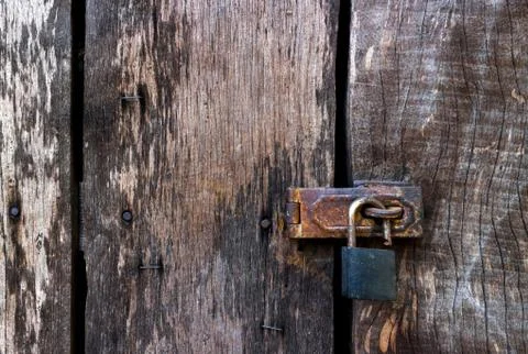 Old master key lock on old wooden background Stock Photos