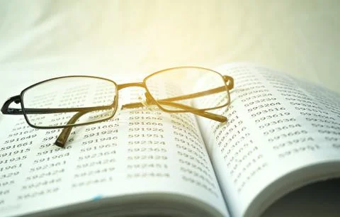 Old math books on blankets with glasses framed him in a quiet scene. Stock Photos