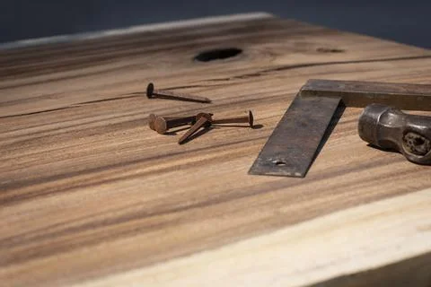 Old measuring tool, hammer and old nails laying on a suar wooden slab 写真素材