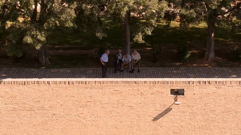Old men on park bench outside the  Palacio de la Aljafería in Zaragoza Stock Footage 98563337