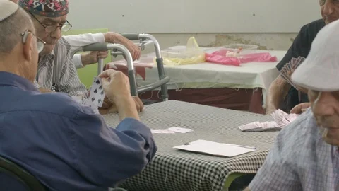 Old men playing cards together Stock Footage 114859779