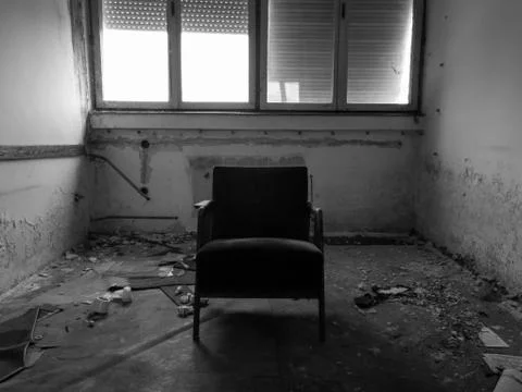 An old messy abandoned office with a dramatic atmosphere and with one chair Stock Photos