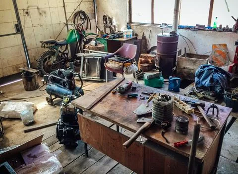 Old messy mechanics workshop with different types of scattered tools. Foto stock