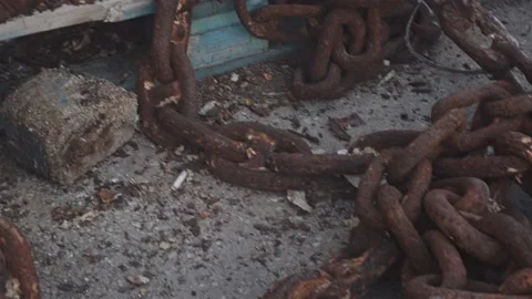 An old metal chain covered with rust from moisture lies on the seashore. A large Stock Footage 220461689