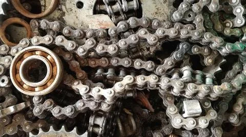 Old metal chains and cogs lined the bike repair shop with black oil stains. 스톡 사진