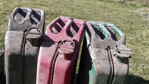 Old Metal Fuel Cans on Grass Representing Global Oil Crisis Stock Footage 333858009