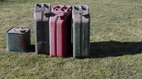 Old Metal Fuel Cans on Grass Symbolizing Global Energy Crisis Stock Footage 333858070