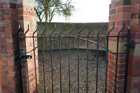 Old Metal Gate Between Brick Pillars In Scarrington, Nottinghamshire, England. Foto stock
